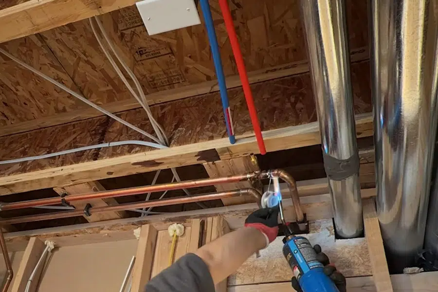 Sink faucet and drain connection being adjusted by hand tools related to Slab leak detection in Arcadia