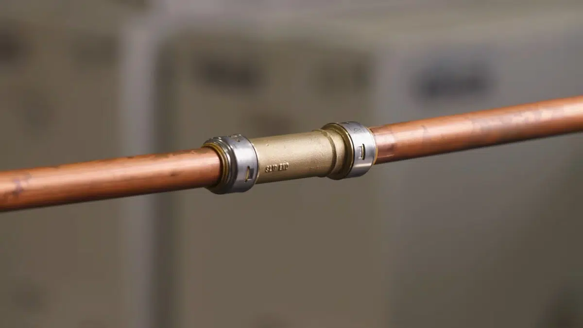 New PEX and copper pipe connections being installed during a repipe related to Burst pipe in a Monrovia home