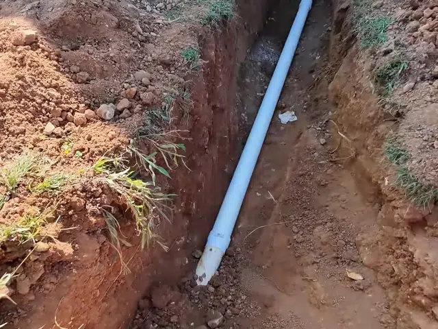 Open trench with new sewer pipe being installed in soil related to Collapsed clay sewer line in Monrovia