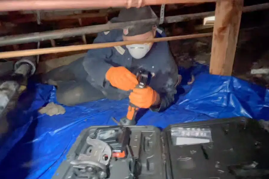 Crawlspace plumbing with drain and supply lines below the floor related to Backflow testing in Monrovia