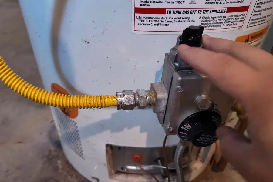 Plumber working on gas water heater piping and controls related to Commercial plumbing in Irwindale