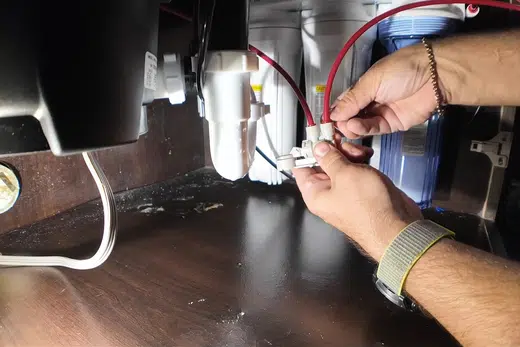Under-sink reverse osmosis filter system connected below a cabinet related to Faucet and Sink Repair in Monrovia