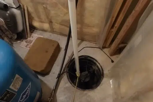 Sump pump basin and pump components being fitted near a foundation related to Glendora CA neighborhood