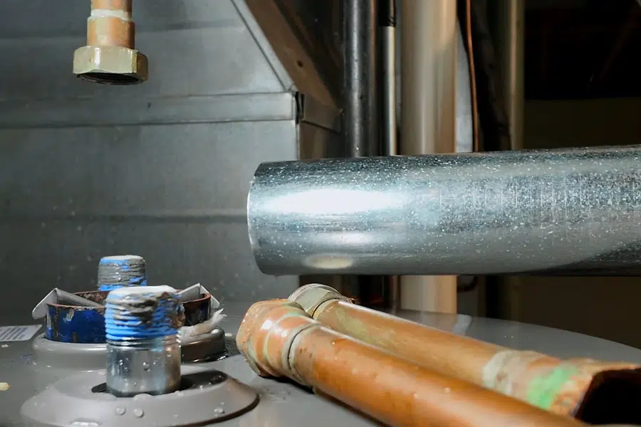 Plumber working on gas water heater piping and controls related to Mission Street district in South Pasadena