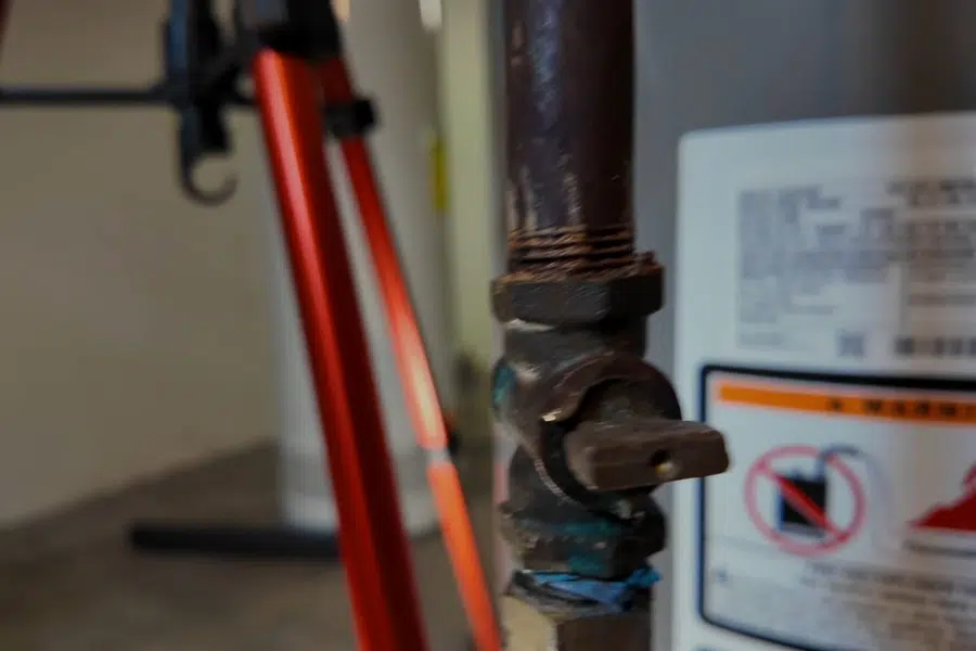 Plumber working on gas water heater piping and controls related to Multi-unit plumbing at Station Square Monrovia