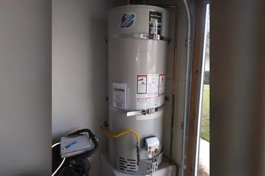 Tank water heater with nearby valves, venting, and supply connections related to North Monrovia neighborhood