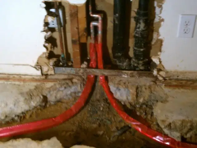 New PEX and copper pipe connections being installed during a repipe related to Repipe access point patched in Monrovia