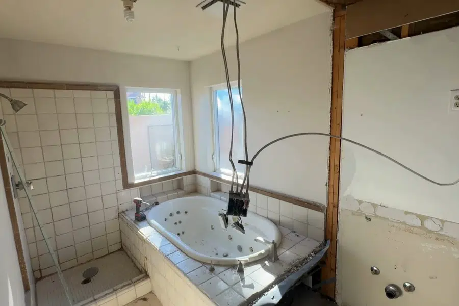 Bathroom rough-in plumbing and fixture area during remodel work related to Preserved historic fixtures in a Monrovia home