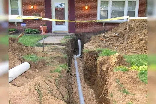 Open trench with new sewer pipe being installed in soil related to Sewer Line Replacement in Monrovia