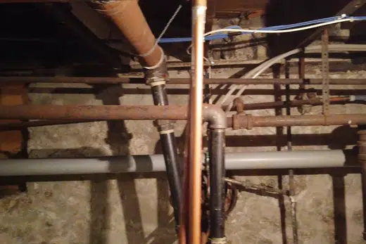 Crawlspace plumbing with drain and supply lines below the floor related to Slab Leaks in Mid-Century Homes, Monrovia plumbing guide