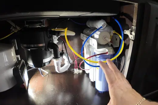 Under-sink reverse osmosis filter system connected below a cabinet related to Water Filtration Installation in Monrovia
